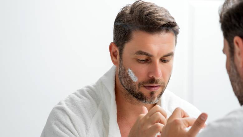 Man applying sun cream to his beard