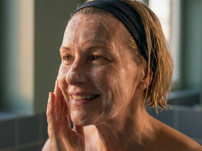lady in her 50s washing her face