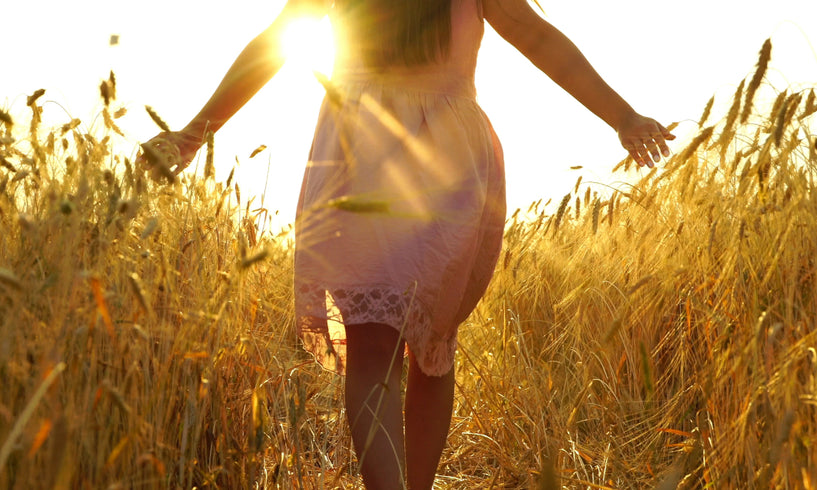 Woman walking through sunny field