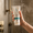 White tube of Green People Daily Aloe Shampoo & Shower Wash being held by a hand in the shower