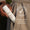 A hand holds a bottle of Green People Scent Free Light Moisturiser tucked inside a beige coat pocket.
