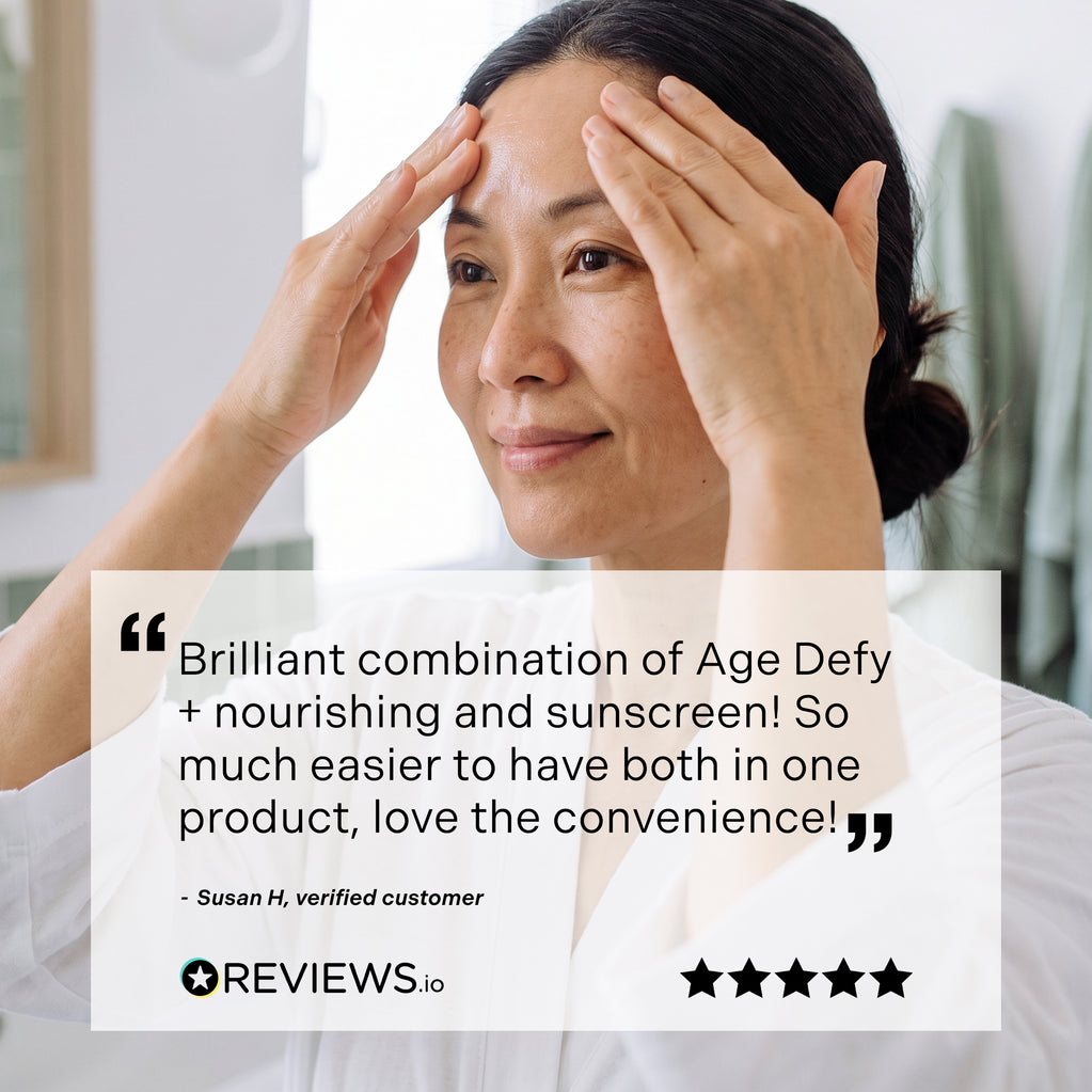 Asian woman applying moisturizer to her forehead with both hands in a bathroom setting, a customer review in the foreground.