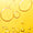 Close-up of yellow essential oil product, showing large and small clear bubbles against a bright yellow background.