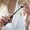 A woman holds the opened Volumising Mascara - Black 7ml tube, pulling out the applicator wand.