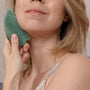 woman using jade gua sha massage tool